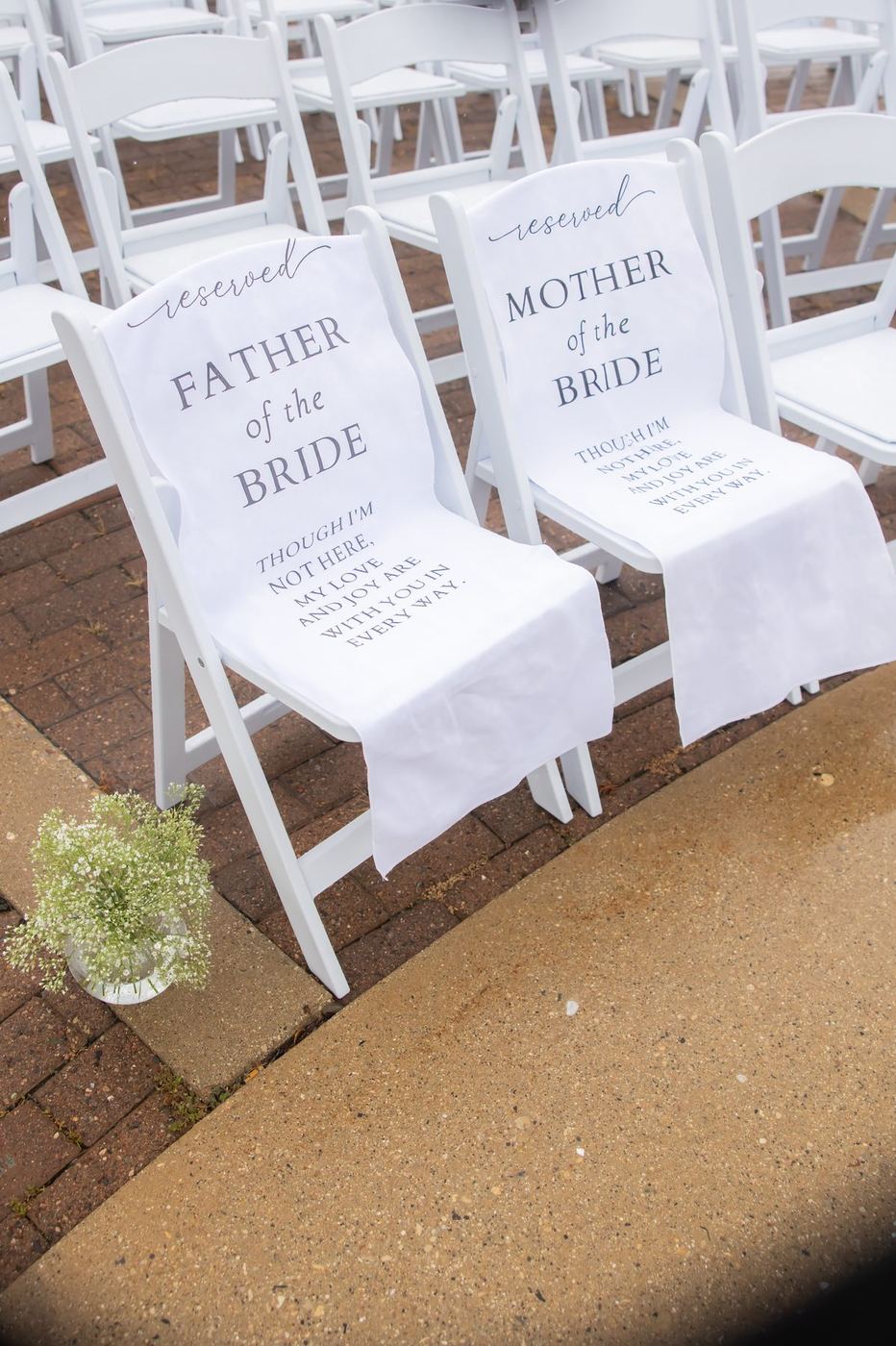 White chair covers reserved for the father and mother of the bride