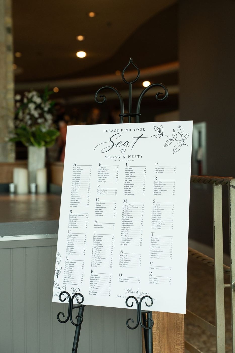 Calligraphy seating chart on a black easel