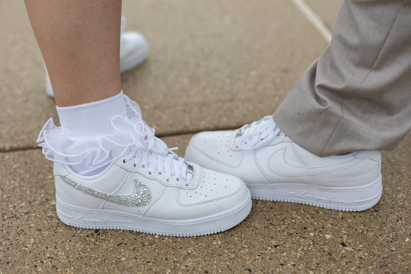 White wedding sneakers, one with a crystal Nike swoosh